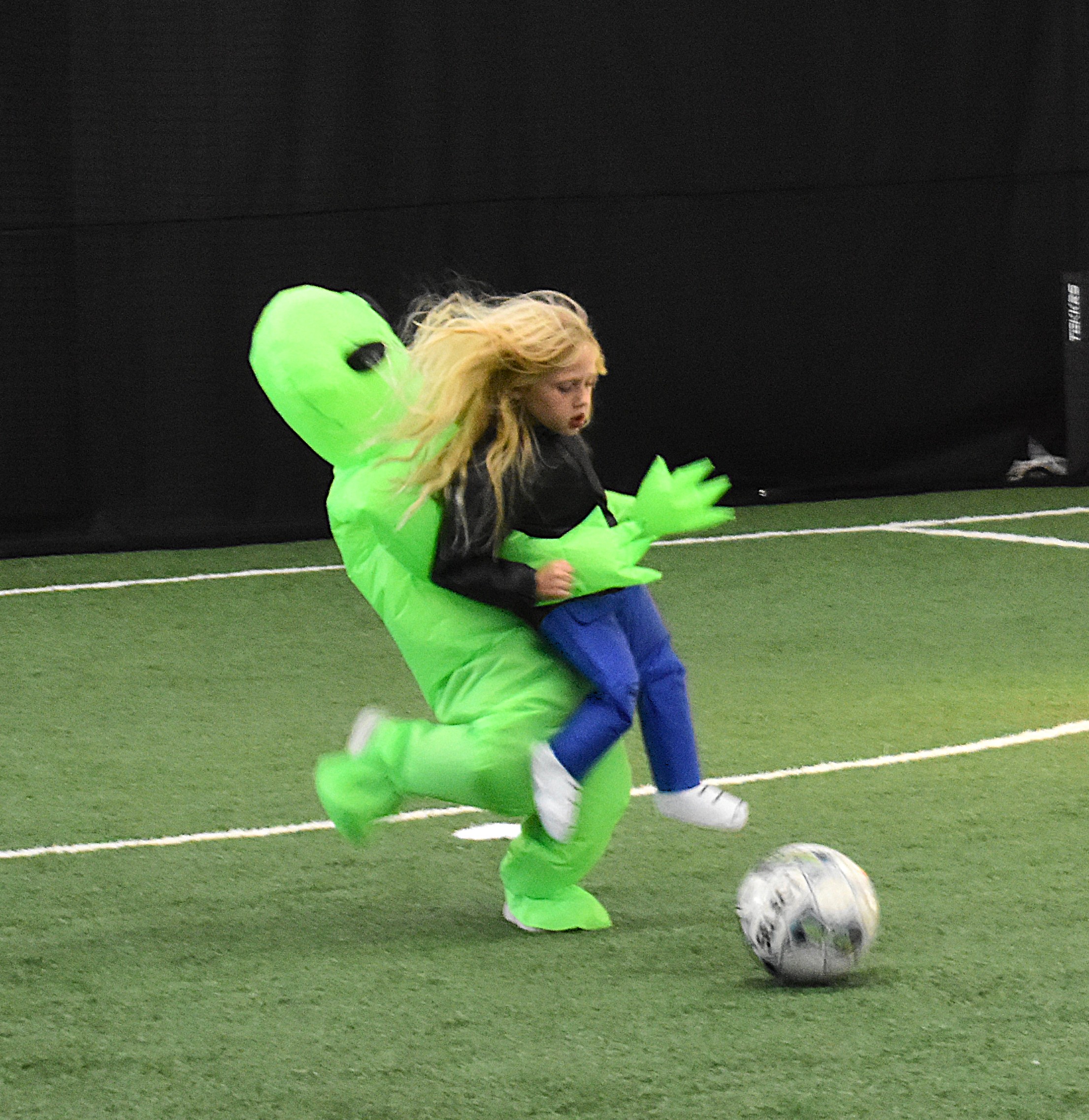 Dallas, 5, dribbles the soccer ball dressed as an alien kidnapping a child.