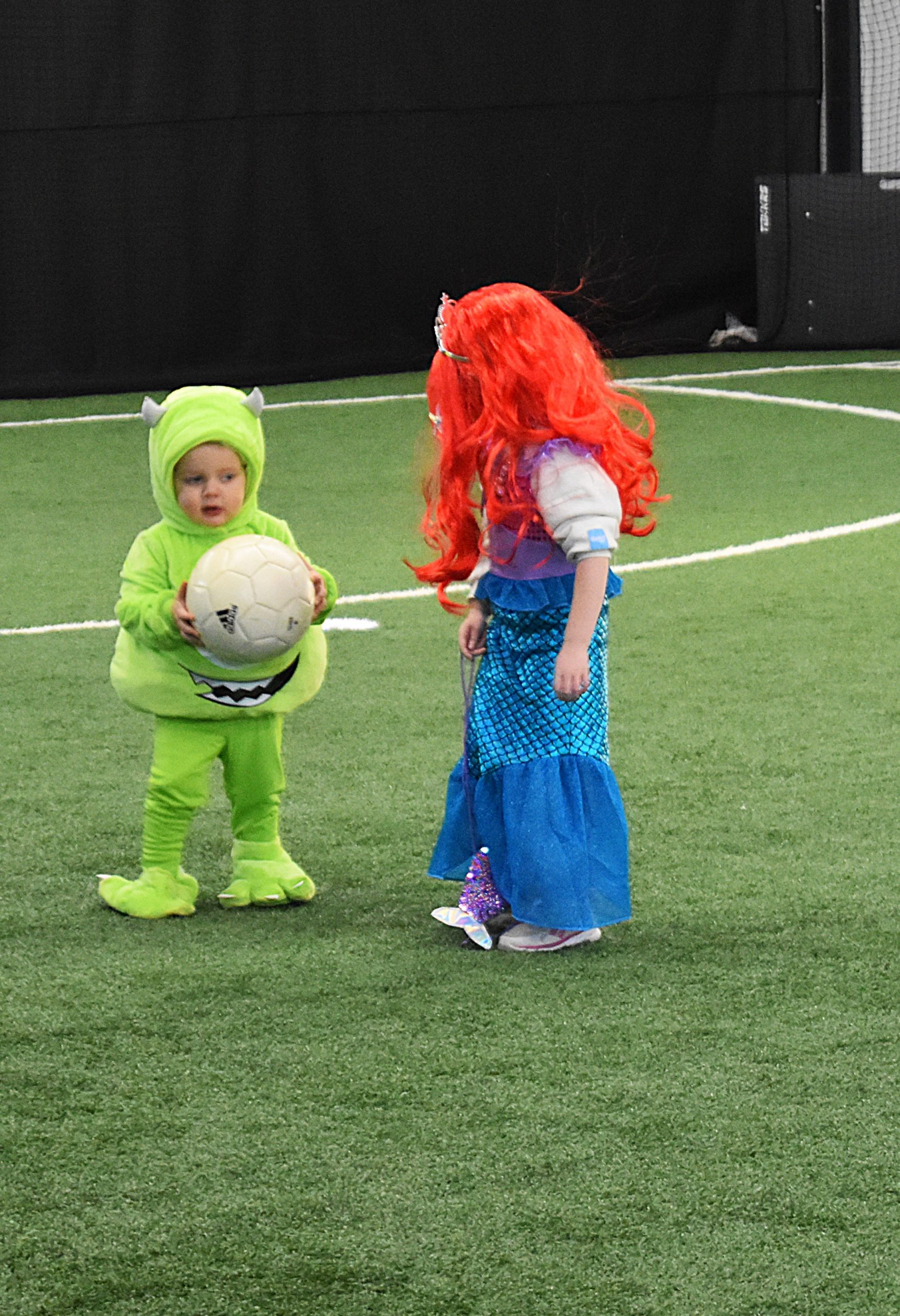 Dallas, 2, dressed as Mike from Monsters Inc. holds soccer ball at Flying Fives Fieldhouse.